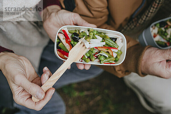 Reife Frau isst Salat mit Mann