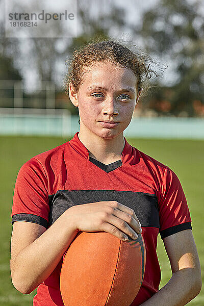 Mädchen mit Rugbyball an einem sonnigen Tag