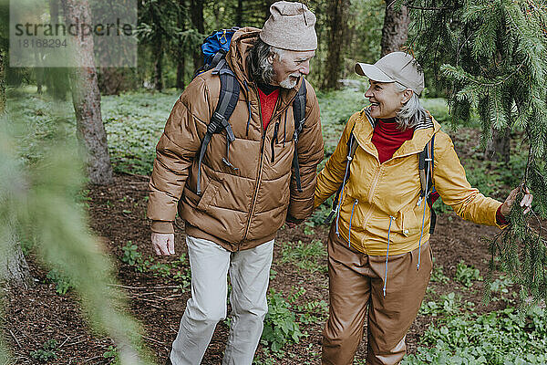 Reife Frau und Mann gehen gemeinsam im Wald spazieren