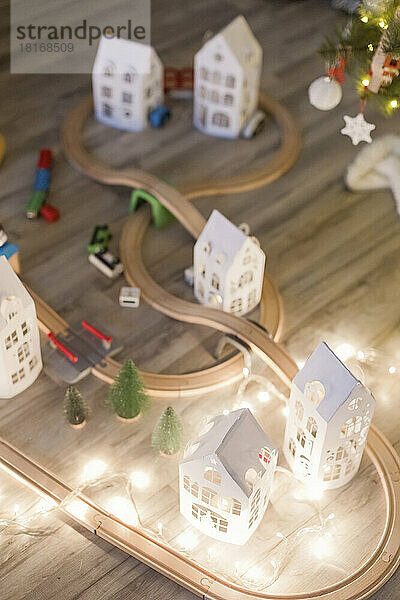Hölzerne Spielzeugeisenbahn mit Lichterkette als Weihnachtsdekoration zu Hause