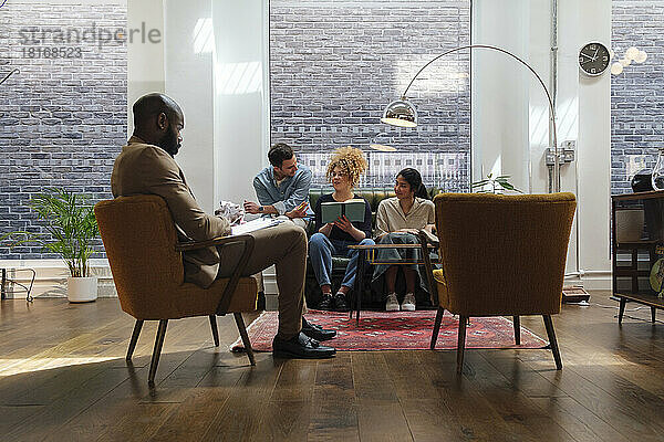 Geschäftsleute sitzen in einem modernen Coworking Space und machen gemeinsam ein Brainstorming