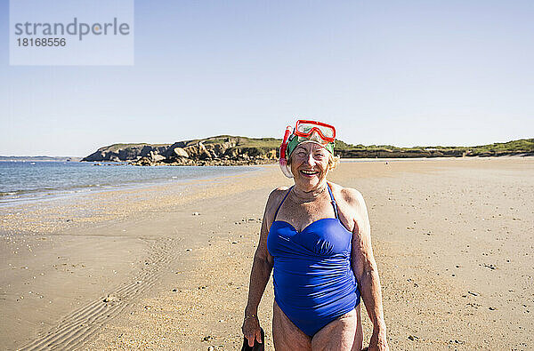 Frau mit Taucherbrille und Schnorchelmaske am Strand
