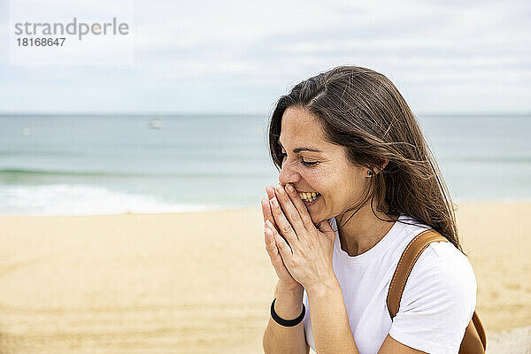 Glückliche Frau mit geschlossenen Augen am Strand