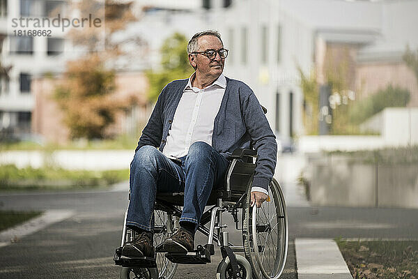 Lächelnder älterer Mann im Rollstuhl in der Stadt