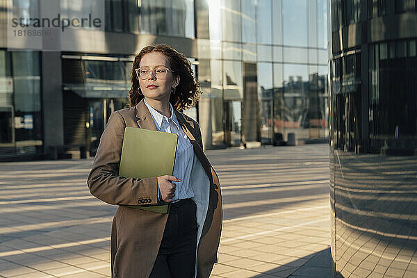 Junge Geschäftsfrau mit Laptop am Bürogebäude in der Stadt