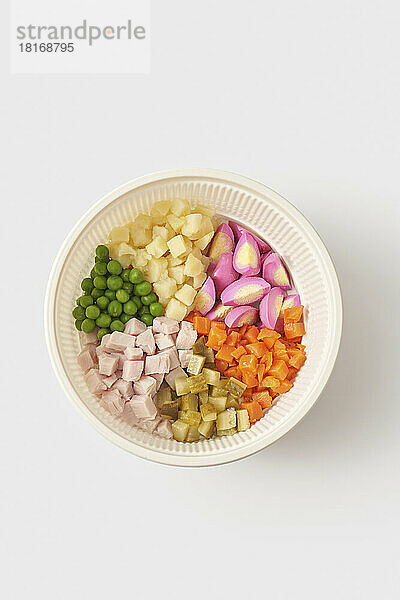 Ingredients for Olivier salad in bowl against white background