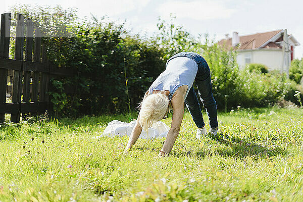 Ältere Frau trainiert auf Gras im Garten