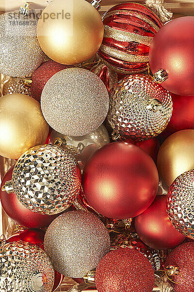 Rote und goldene Weihnachtskugeln mit strukturierter Oberfläche