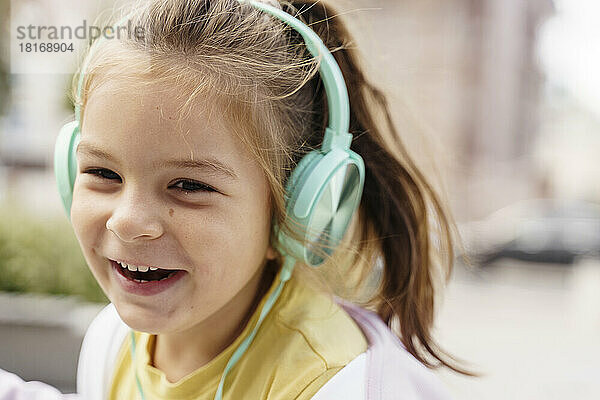 Fröhliches Mädchen  das über Kopfhörer Musik hört