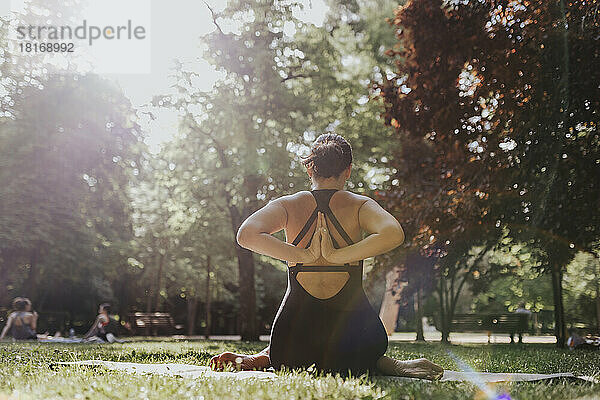 Fitnesstrainer macht Stretching-Yoga im Park