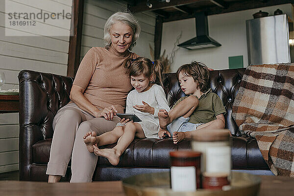 Kinder bringen Großmutter bei  wie man zu Hause einen Tablet-PC benutzt
