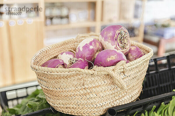 Wicker basket with fresh rutabaga in greengrocer shop