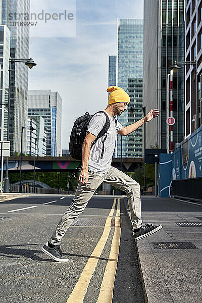 Mann mit Strickmütze läuft auf der Straße in der Stadt
