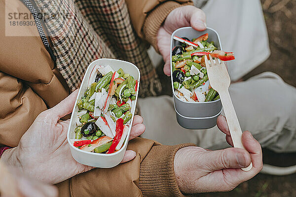 Paar mit gesundem Salat in der Lunchbox