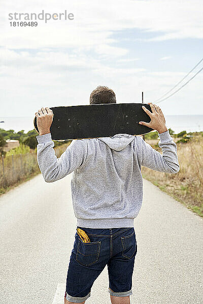 Mann mit Banane in der Tasche und Skateboard auf den Schultern