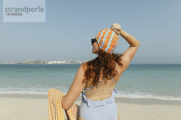 Frau im Badeanzug genießt sonnigen Tag am Strand