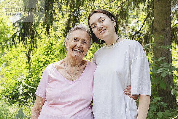 Glückliche Seniorin mit Enkelin steht im Park