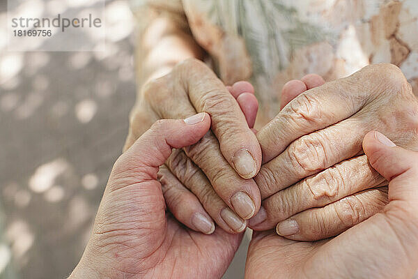Ältere Frau hält die Hände ihrer Enkelin