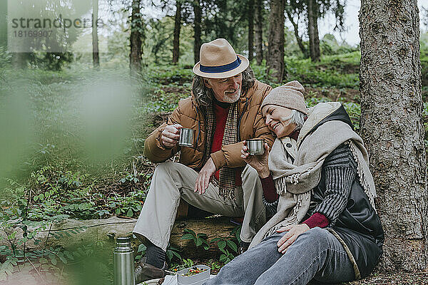 Reife Frau und Mann trinken heißen Tee im Wald