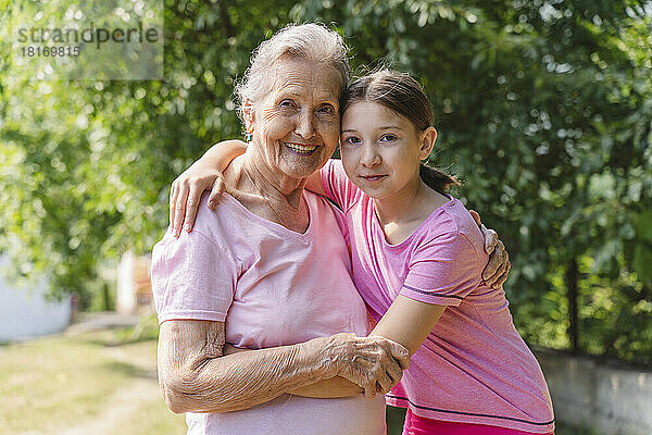 Glückliche Seniorin umarmt Enkelin im Park