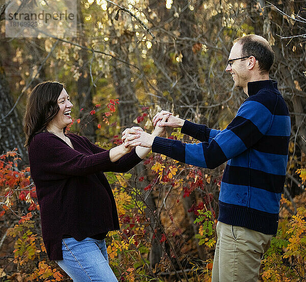 Ein reifes Ehepaar verbringt Zeit miteinander und tanzt im Herbst in einem Stadtpark; St. Albert  Alberta  Kanada