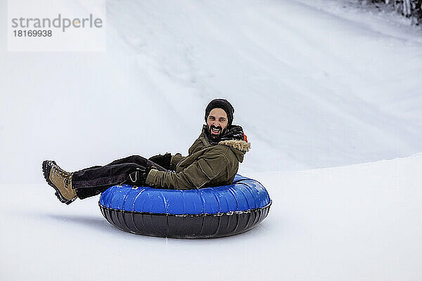 Mann beim Tubing auf einem Skihügel; Fairmont Hot Springs  British Columbia  Kanada