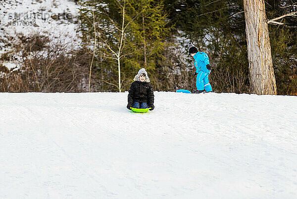 Zwei Jungen rodeln einen Hügel in einem Wintersportort hinunter; Fairmont  British Columbia  Kanada