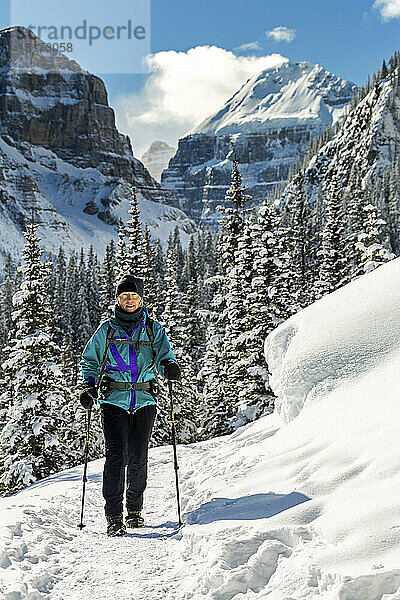 Wanderung auf einem schneebedeckten Weg mit schneebedeckten Bäumen und Rocky Mountains im Banff National Park; Lake Louise  Alberta  Kanada