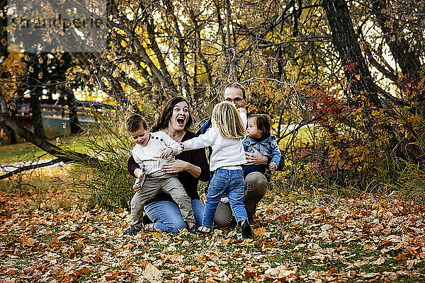 Junge Familie mit drei Kindern  die jüngste Tochter mit Down-Syndrom  vergnügt sich während der Herbstsaison in einem Stadtpark; St. Albert  Alberta  Kanada
