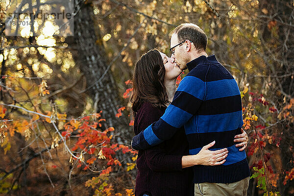 Reifes Ehepaar küsst sich  während sie im Herbst in einem Stadtpark Zeit miteinander verbringen; St. Albert  Alberta  Kanada