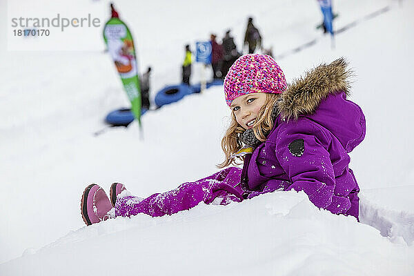 Junges Mädchen wartet am Rande eines Skihügels  während ihre Familie Tubing fährt; Fairmont Hot Springs  British Columbia  Alberta