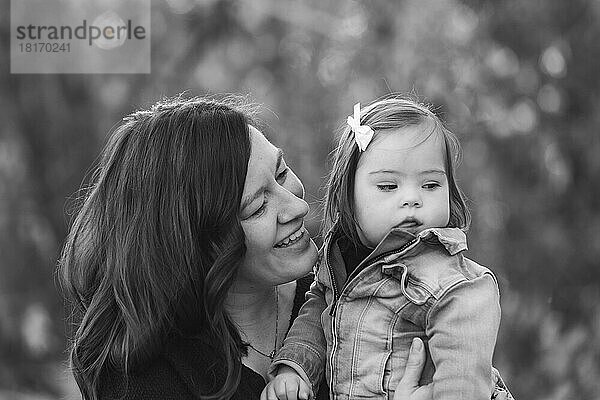 Porträt einer Mutter und ihres kleinen Mädchens mit Down-Syndrom  die während eines Familienausflugs in einem Stadtpark viel Zeit im Freien verbringen; St. Albert  Alberta  Kanada