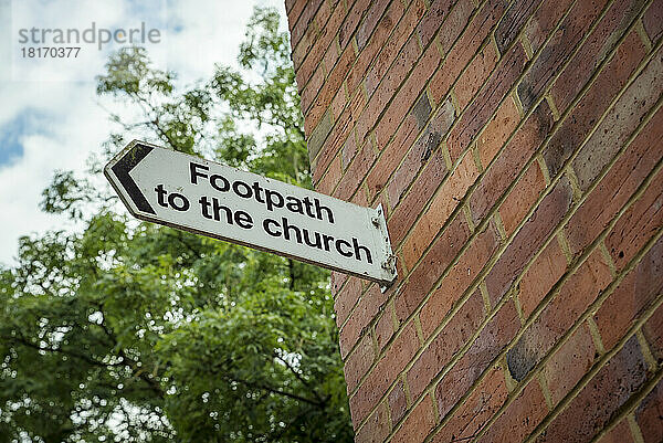 Schild Fußweg zur Kirche an einer Ziegelmauer; Rockbourne  Wiltshire  England