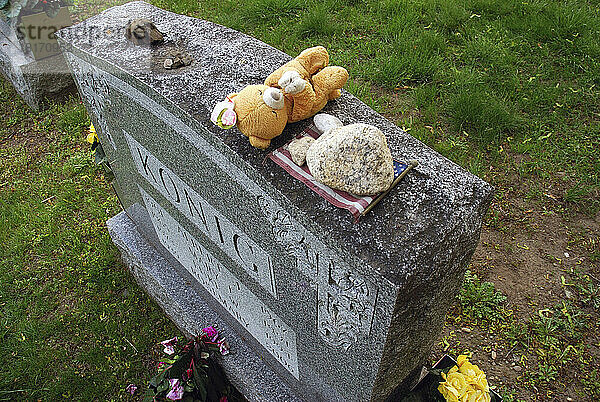 Ein mit Erinnerungsstücken geschmückter Grabstein am Memorial Day; Arlington  Massachusetts.