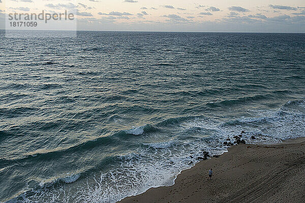 Ein Mann geht am Strand der Florida-Küste entlang; Palm Beach  Florida  Vereinigte Staaten von Amerika