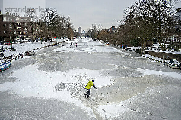 Schlittschuhläuferin allein auf einer Gracht; Amsterdam  Niederlande