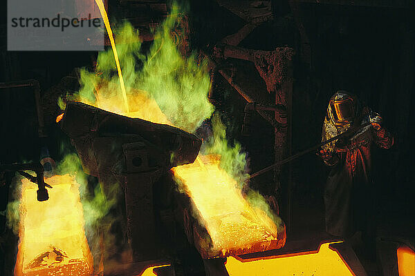 Ein Mann in Schutzkleidung bedient einen Schmelzofen der Magma Metals Company in der Nähe von San Manuel  Arizona  USA; Arizona  Vereinigte Staaten von Amerika