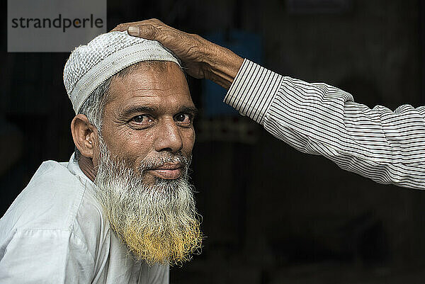 Hand auf dem Kopf eines muslimischen Ladenbesitzers in Jaipur  Indien; Jaipur  Rajasthan  Indien