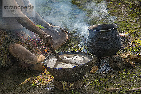 Rühren einer Speise aus Sago in Karawari  in der Sepik-Region von Papua-Neuguinea. Sago wird in Form von Mehl hergestellt  das normalerweise aus der Palme gewonnen wird. Sago ist ein gängiger Bestandteil der Küche Papua-Neuguineas  da die Stärkezutat in mehreren traditionellen Gerichten wie Pfannkuchen und Pudding enthalten ist; Sepik  Papua-Neuguinea