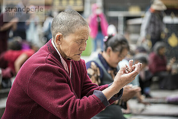 Pilger beim Beten in Lhasa mit Gebetsperlen; Lhasa  Autonome Region Tibet  Tibet