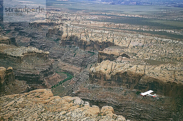 Ein kleines Flugzeug fliegt über dem Colorado River in einer Schlucht im Canyonlands National Park; Utah  Vereinigte Staaten von Amerika