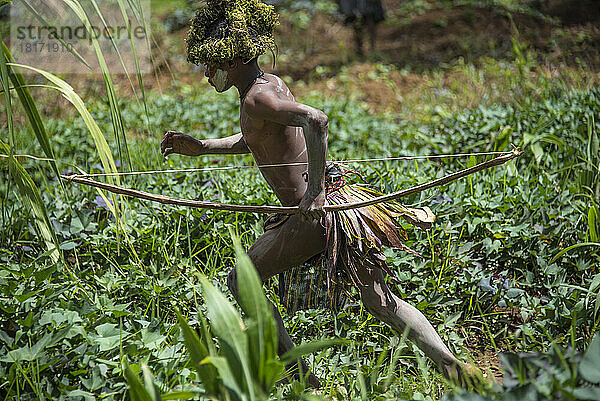 Junges Mitglied des Huli-Stammes im Tari-Tal im südlichen Hochland von Papua-Neuguinea  das eine Perücke trägt  die als Teil seines Übergangs zum Erwachsensein angefertigt wurde; Tigibi  südliches Hochland  Papua-Neuguinea