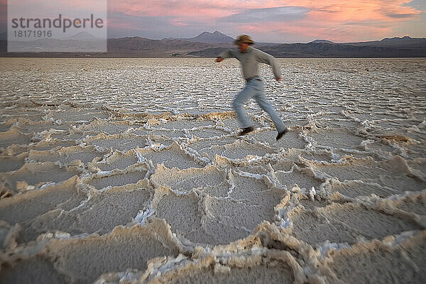 Bewegungsunschärfe eines Mannes  der über die Oberfläche der Salar de Atacama-Salzwüste in Chile läuft; Atacama-Wüste  Chile