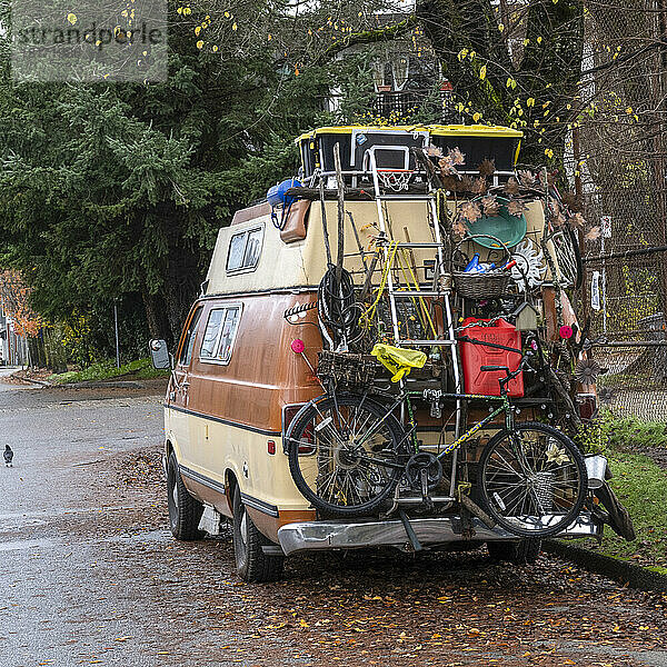 Ein Wohnmobil  beladen mit Haushaltsgegenständen und einem Fahrrad  geparkt und in einer Wohnstraße; Vancouver  British Columbia  Kanada