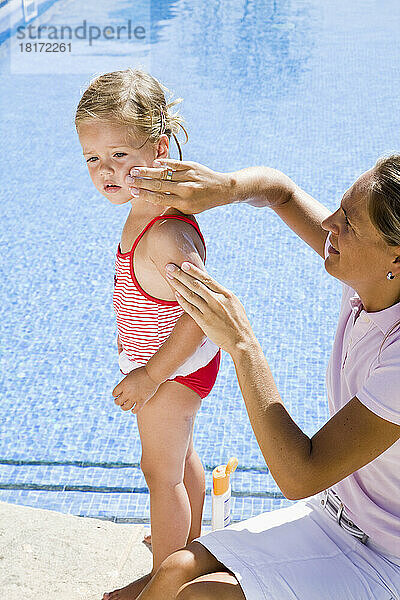 Mutter trägt Sonnencreme auf das Gesicht ihrer Tochter auf