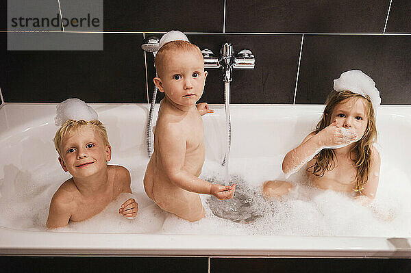 Drei Kinder baden in der Badewanne