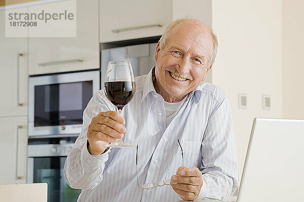 Porträt eines Mannes  der ein Glas Wein erhebt