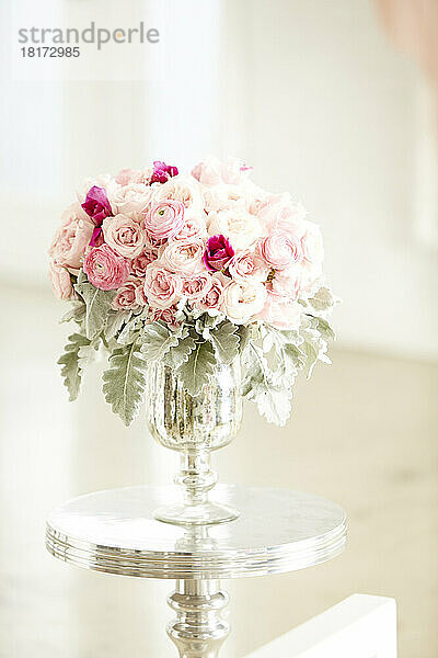 Strauß rosa Rosen in silberner Vase auf silbernem Tisch  Studioaufnahme