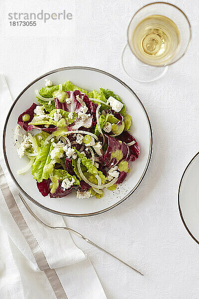 Römersalat und Endiviensalat mit einem Glas Weißwein