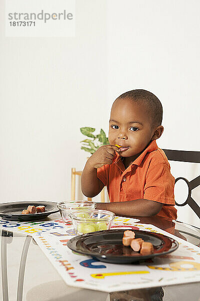Junge isst Mittagessen am Küchentisch